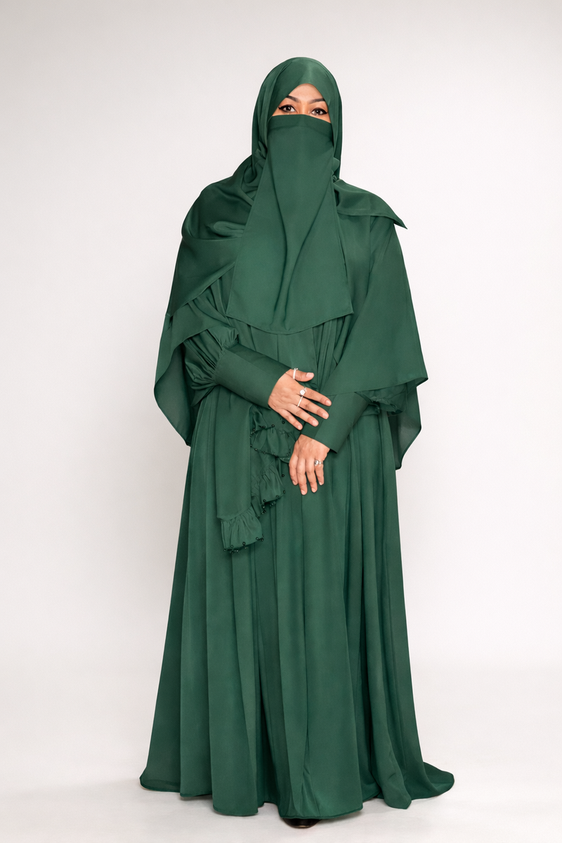 Person wearing a green abaya with a matching hijab on a white background